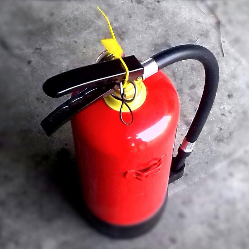 Red fire extinguisher with a yellow tag.