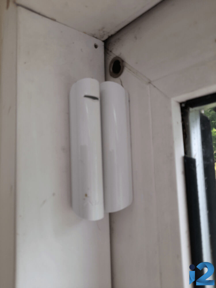 Ajax DoorProtect Plus contact sensor on a sliding door.