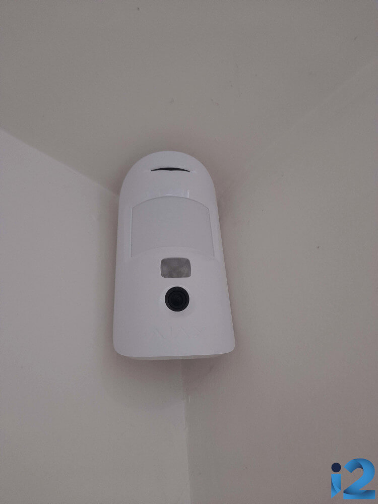 Ajax MotionCam in the hallway of a family home.