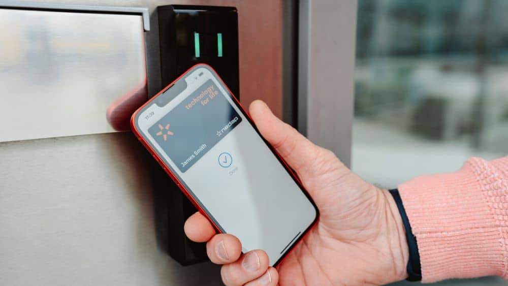 Nedap Mobile Access smartphone credential being presented to a Nedap access control reader at a door.